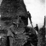 men clmingin ladders and croching to examine stonework
