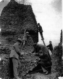 men clmingin ladders and croching to examine stonework